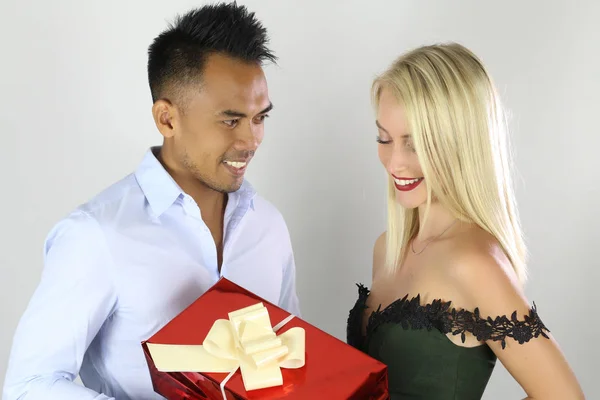 Un joven guapo le está dando un regalo a su encantadora novia. —  Fotos de Stock