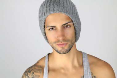 Gri bir şapka giymiş yakışıklı maço adam 