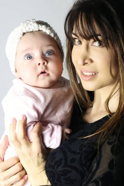 Güzel anne onun güzel kız bebek beyaz bir arka plan üzerinde tutan 