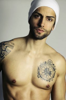 dövmeli adam beyaz bir arka plan üzerinde poz kusursuz bir beden ile. Seksi erkek model üstsüz poz 