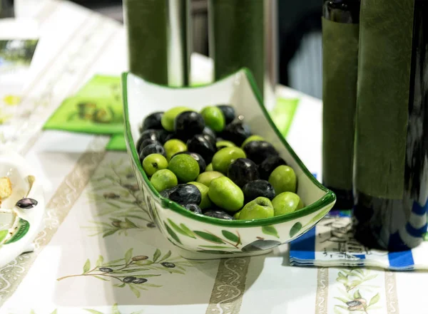 Azeitonas verdes e pretas em chapa de porcelana em uma mesa — Fotografia de Stock