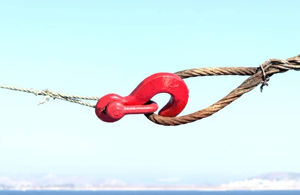 Red hook hooked the rope on the sky background — Stock Photo, Image