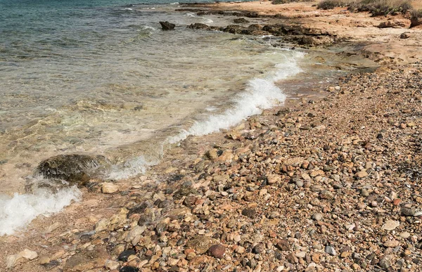Deniz kıyısında küçük çakıl taşları ile görünümünü — Stok fotoğraf