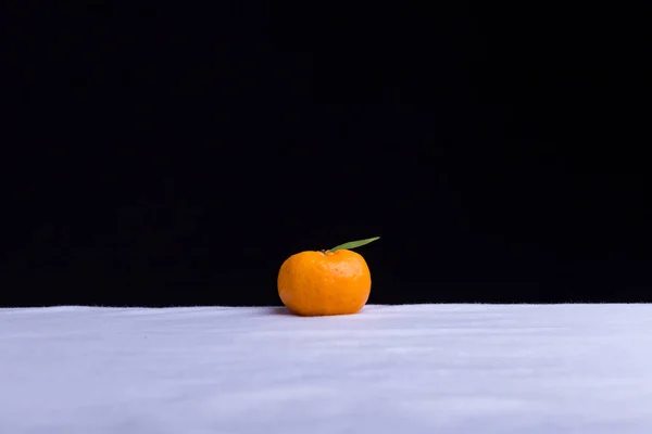 Laranja mandarim sobre um fundo preto — Fotografia de Stock