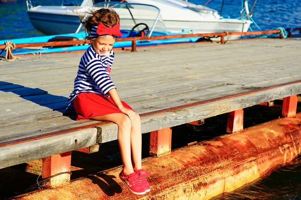 Ung flicka sitter på bryggan — Stockfoto