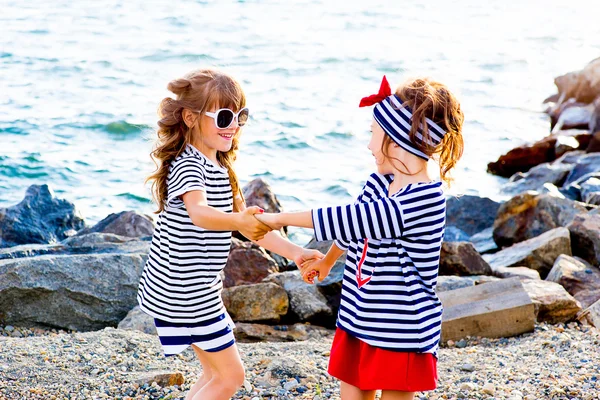 Twee jonge meisjes in de buurt van de zee-rots — Stockfoto