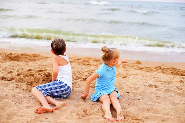 Två barn som leker på stranden — Stockfoto