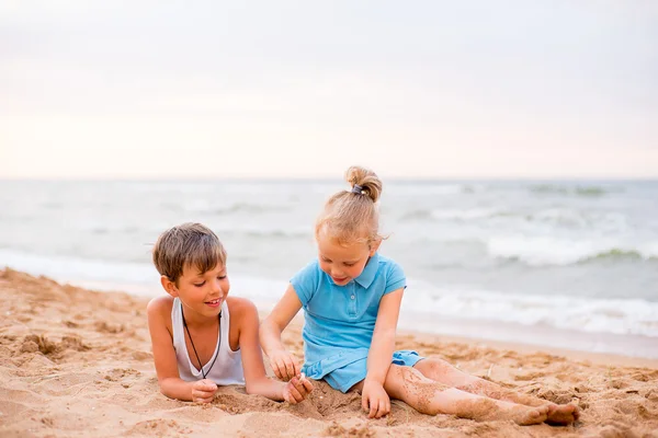 Två barn som leker på stranden — Stockfoto