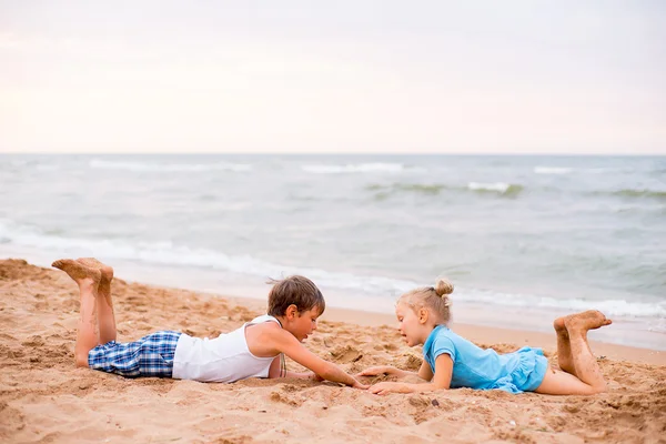 Två barn som leker på stranden — Stockfoto