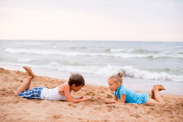 Två barn som leker på stranden — Stockfoto