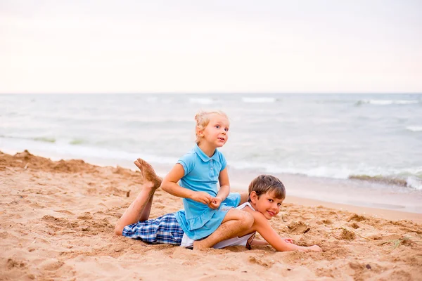 Två barn som leker på stranden — Stockfoto