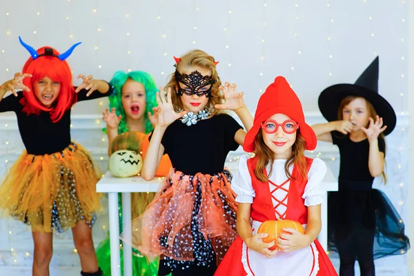 Grupo feliz de crianças em trajes durante a festa de Halloween — Fotografia de Stock