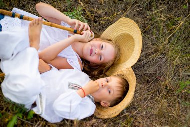 Kız ve erkek kardeşim çimlere oturup