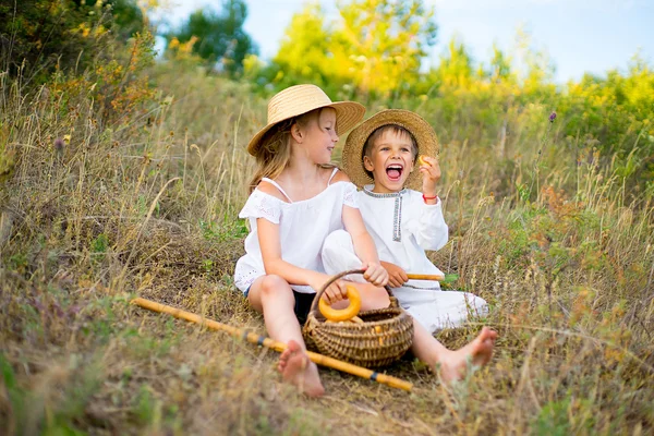 Bror och syster sitta på gräset — Stockfoto