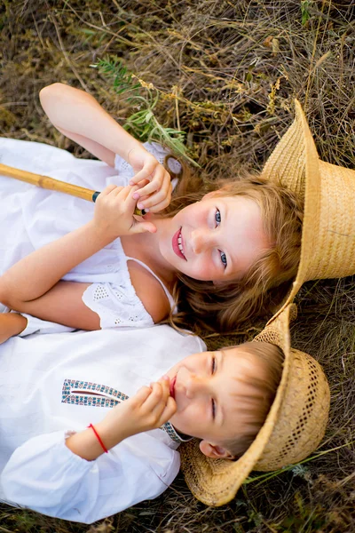 Bruder und Schwester sitzen auf Gras — Stockfoto