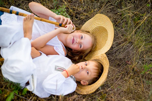 Kız ve erkek kardeşim çimlere oturup
