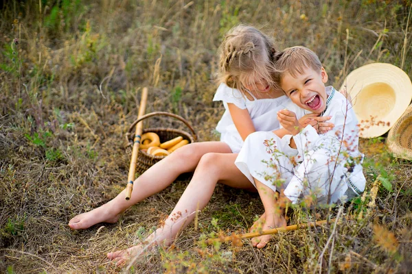 Kız ve erkek kardeşim çimlere oturup