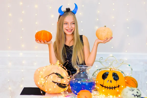 Adolescente chica en traje de demonio posando con calabazas — Foto de Stock