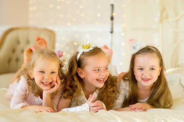 Три маленькие девочки на кровати — стоковое фото