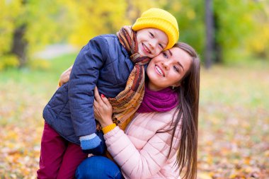 çocuk annesi sonbahar parkta hugs.