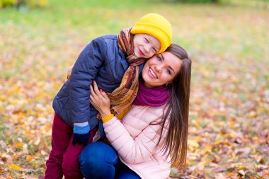 çocuk annesi sonbahar parkta hugs.
