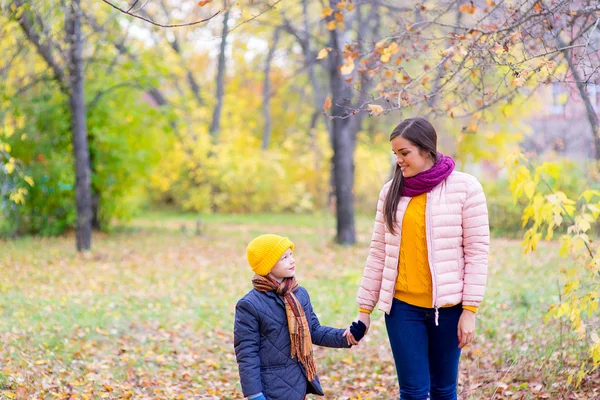 Boy walking with his mother in autumn park — Stock Photo, Image