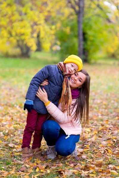 Niño abraza a su madre en el parque de otoño — Foto de Stock