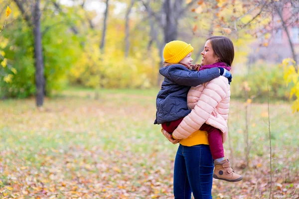 Madre con giovane figlio su mani autunno parco — Foto Stock