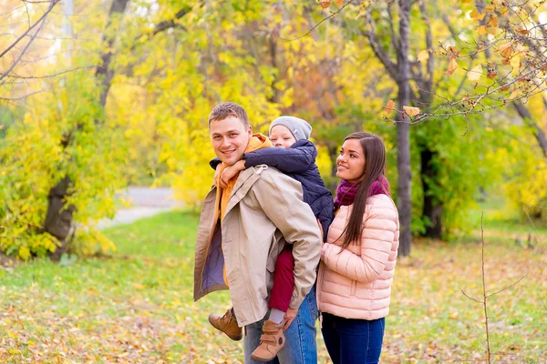Anya és apa és fia az ő vissza őszi parkban — Stock Fotó