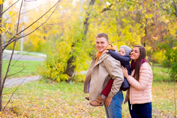 Anya és apa és fia az ő vissza őszi parkban — Stock Fotó