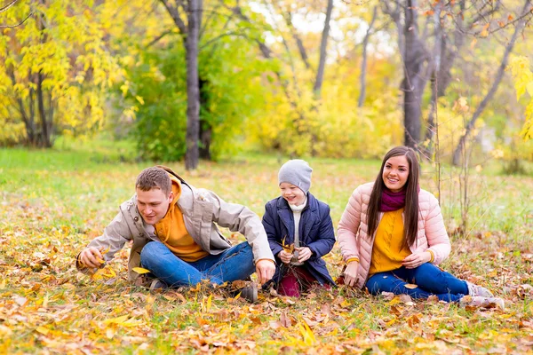 Família brincando com folhas parque de outono — Fotografia de Stock