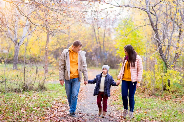 Family of three walks in the autumn park — Stock Photo, Image