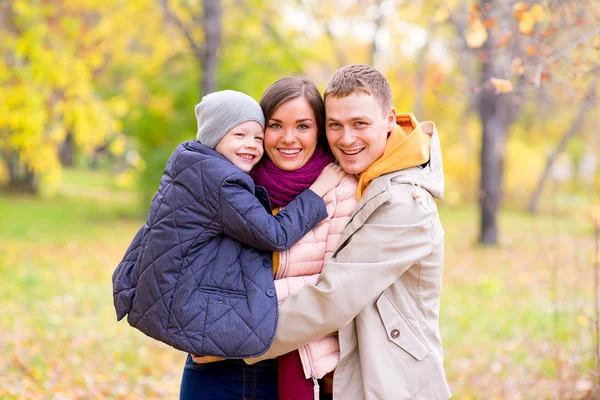 Padre y madre con hijo pequeño en las manos Autumn Park — Foto de Stock