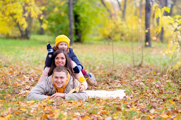 Family lying on the leaves autumn park — Stock Photo, Image