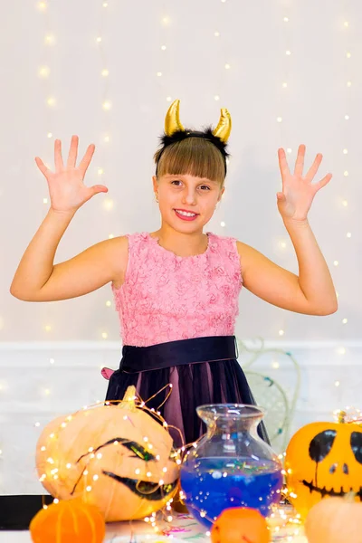 Teenager girl in demon costume posing with pumpkins — Stock Photo, Image
