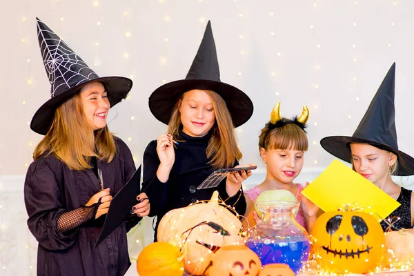 Lykkelig gruppe af teenagere i kostumer forbereder sig til Halloween - Stock-foto