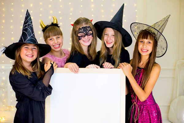 Grupo de adolescentes con disfraces de Halloween posando con blanco — Foto de Stock