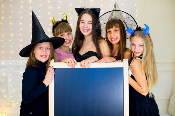 Group of teenagers wearing Halloween costumes posing with black — Stock Photo, Image