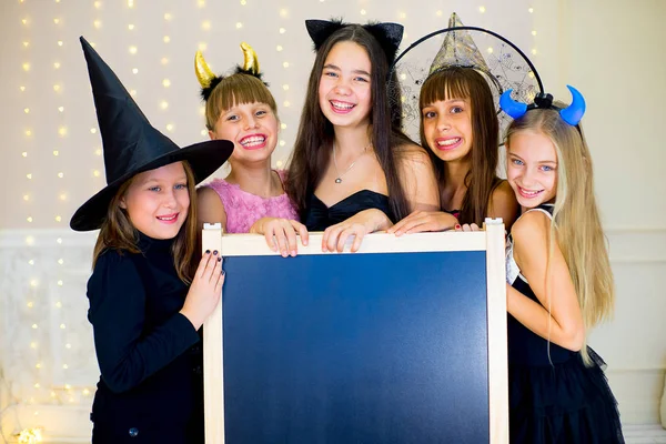 Grupo de adolescentes con disfraces de Halloween posando con negro —  Fotos de Stock