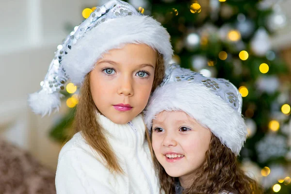 Due ragazze, regalo, albero di Natale, cappelli bianchi — Foto Stock