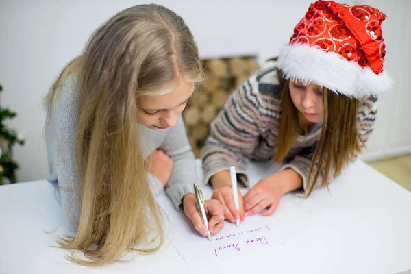 two girls write a letter to Santa Claus