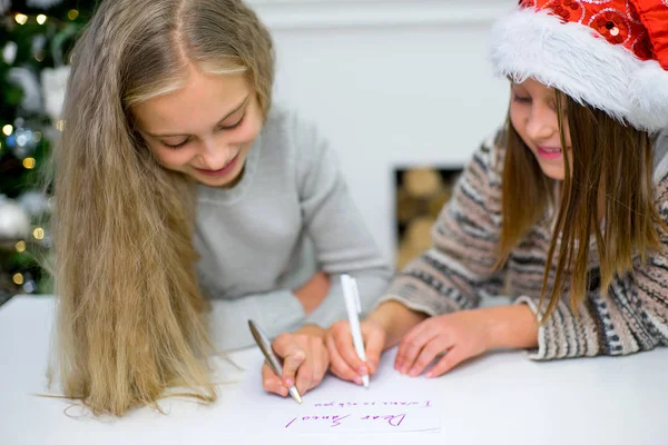 two girls write a letter to Santa Claus