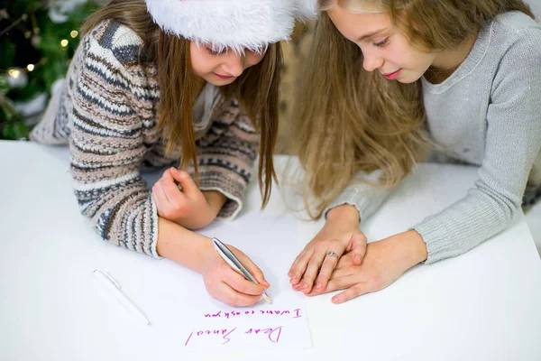 two girls write a letter to Santa Claus