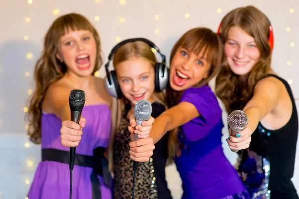 Groupe de filles heureuses chantant sur le karaoké — Photo