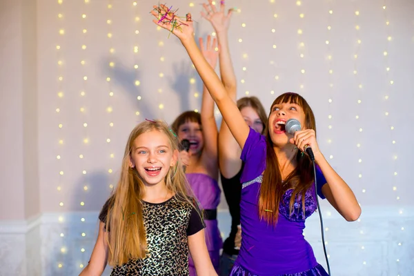 Boldog lány énekelni a karaoke csoport — Stock Fotó