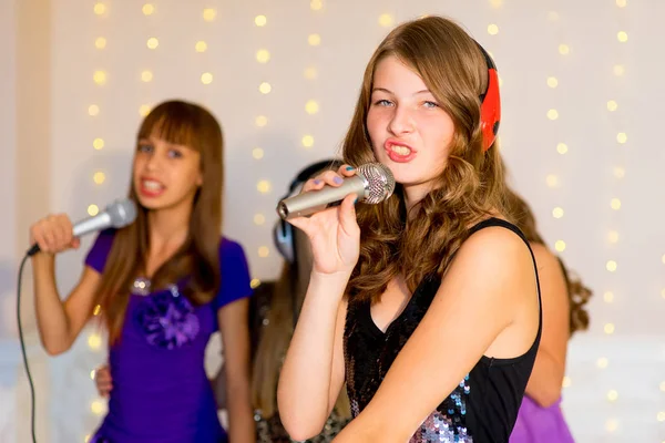 Groupe de filles heureuses chantant sur le karaoké — Photo
