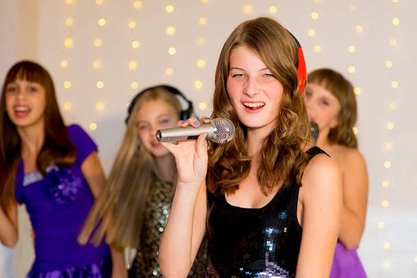 Boldog lány énekelni a karaoke csoport — Stock Fotó