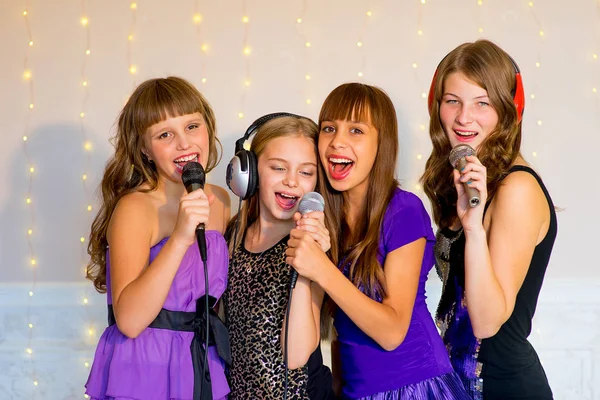 Group of happy girls singing on karaoke Stock Image