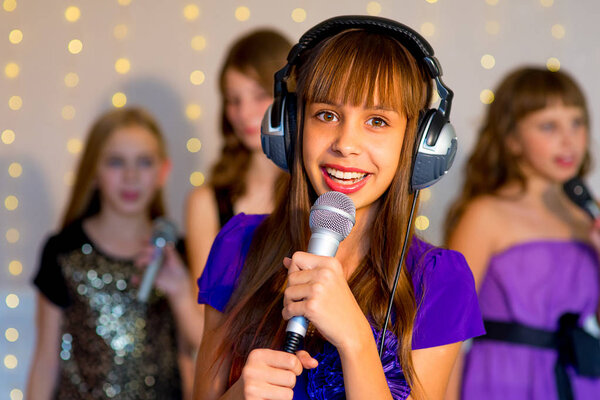 Группа счастливых девушек поет в караоке
