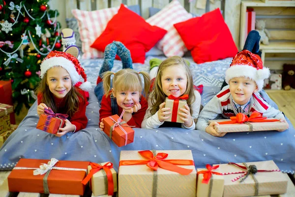Ομάδα παιδιών με το κόκκινο καπέλο με τα δώρα Χριστουγέννων — Φωτογραφία Αρχείου